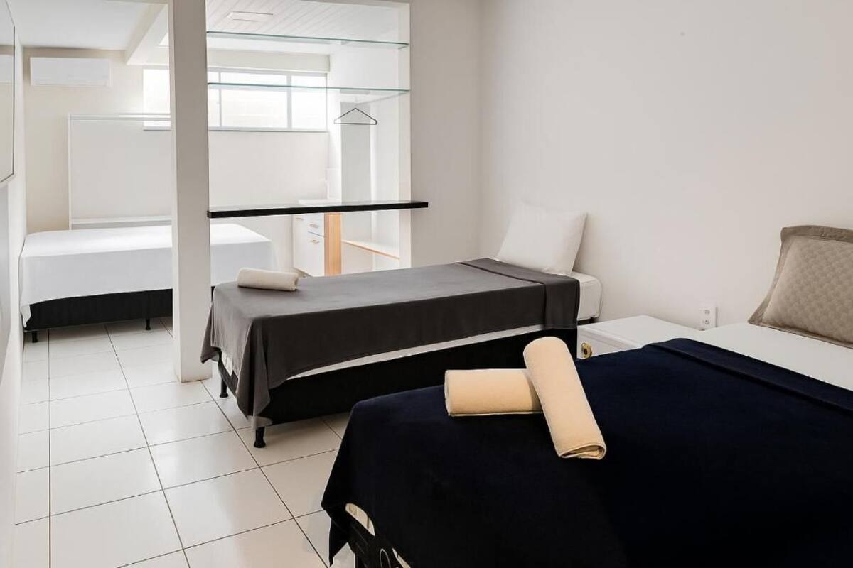A modern hotel room with a bed, a small desk, and a window.
