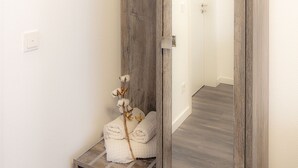 A bathroom with a wooden vanity, a mirror, and towels. - Hotel Zur Feldmühle  (Arnsberg)