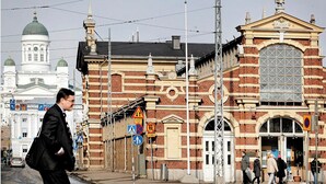 A historic building with a large arched entrance and a clock tower in the background. - Superior Suite by the Sea and Market Square (Helsinki)