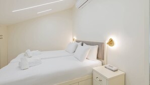 Ein Hotelzimmer mit Bett, Nachttischen und einer Klimaanlage.