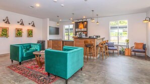 A spacious living area with teal sofas, a wooden coffee table, and a red patterned rug. - Landing Spectacular 1bd, Courtyard (Springfield)