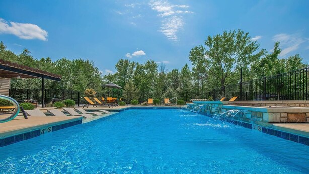 A swimming pool with lounge chairs and a small waterfall feature. - Landing Spectacular 1bd, Courtyard (Springfield)