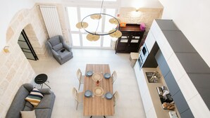 Eine moderne Küche mit Essbereich, einer Couch und einem Kamin.