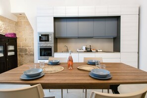 Eine moderne Küche mit Einbauofen, Mikrowelle und einem großen grauen Schrank über der Arbeitsplatte.