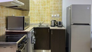 A kitchen with a microwave, toaster, kettle, and a refrigerator. - 35 OFF in Top View Studio in Marina (Dubai)
