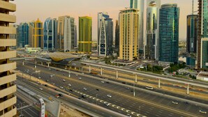 A cityscape with modern high-rise buildings, a multi-lane highway, and a distinctive curved building. - 35 OFF in Top View Studio in Marina (Dubai)