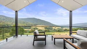 Un balcon spacieux offrant une vue dégagée sur un paysage vallonné.