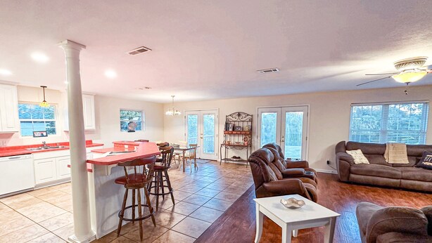 A spacious living area with a kitchen, dining table, and seating. - Grand Lagoon Retreat | Blue Angels & Boat Parking (Pensacola)