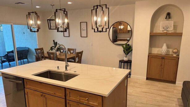 A kitchen with a large island, wooden cabinets, and pendant lighting. - Entire Home/Gated/King On suite (Tucson)