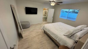 A bedroom with a bed, a ceiling fan, a window, and a door. - Entire Home/Gated/King On suite (Tucson)