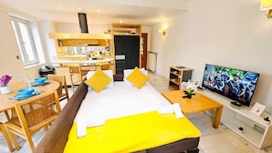 A modern hotel room with a bed, a dining area, a TV, and a kitchenette. - Smart Retreat next to Luxembourg Station (Luxembourg City)