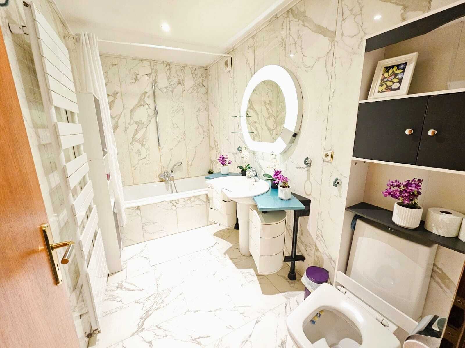 Un bagno moderno con vasca, lavabo e water.