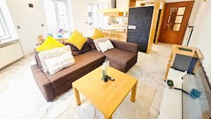 A modern living room with a brown sofa, yellow and white cushions, a wooden coffee table, and a small plant. - Smart Retreat next to Luxembourg Station (Luxembourg City)