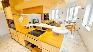 A modern kitchen with a central island, built-in oven, and wooden cabinetry. - Smart Retreat next to Luxembourg Station (Luxembourg City)