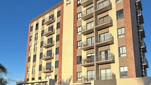 A multi-story building with a flat roof, large windows, and a central entrance. - Alfina Inn, space created for your comfort, river view, privileged terrace. (Encarnación)