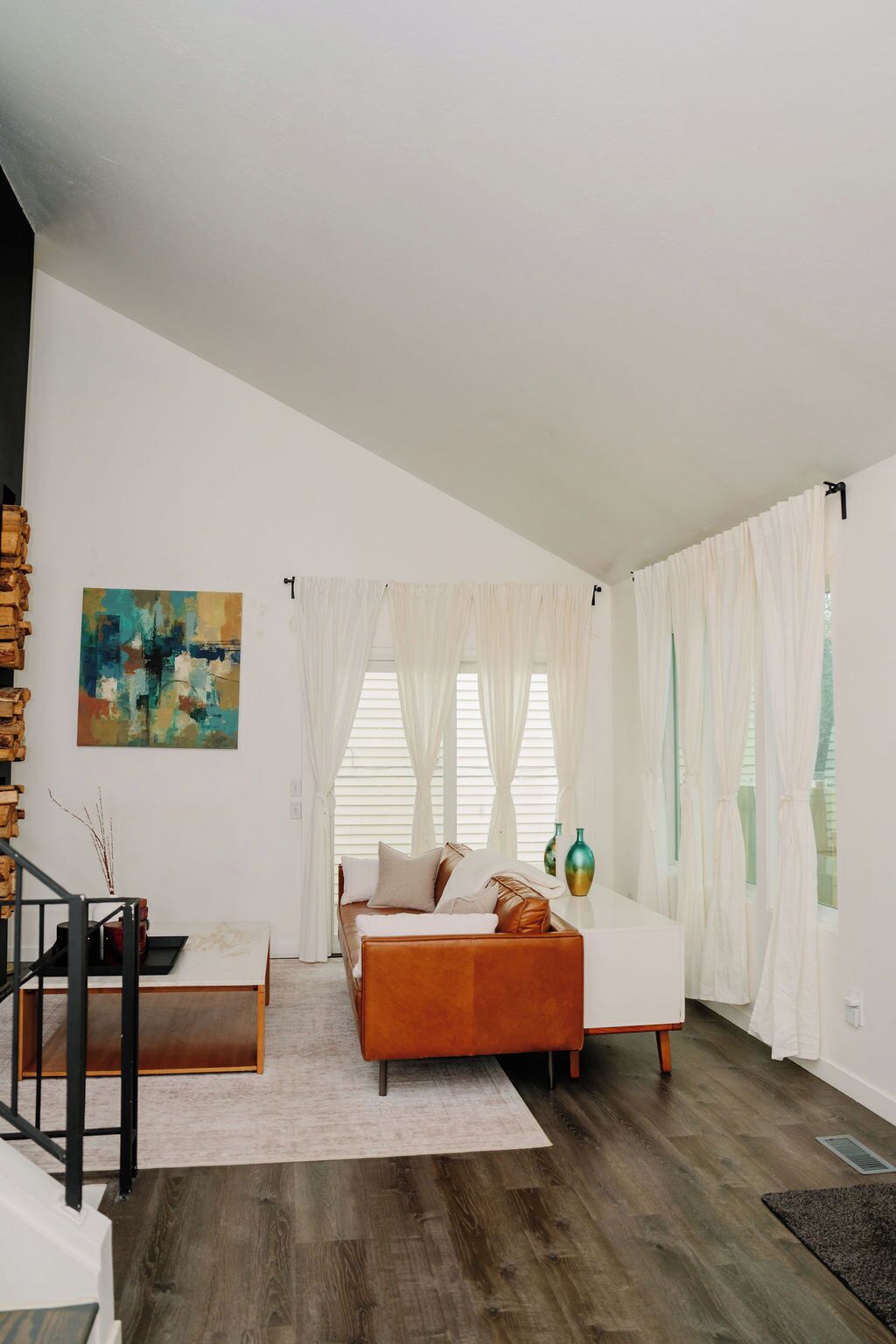 A modern living room with a sofa, a coffee table, and a staircase.