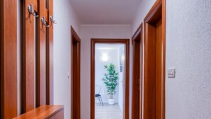 Ein Korridor mit Holztüren, einem Blumentopf und einem Stuhl.