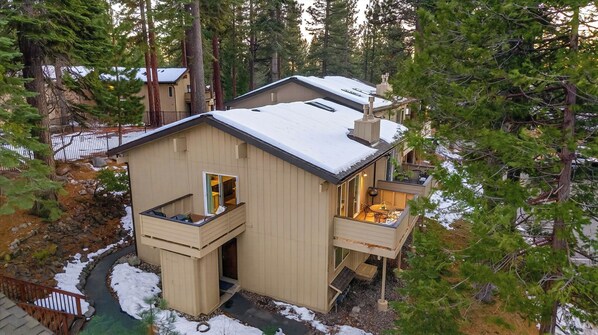 A cabin with a balcony, a deck, and a chimney.