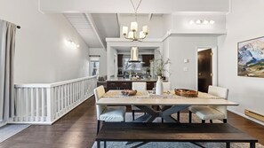 Un espace repas comprenant une table en bois, des chaises et un lustre.