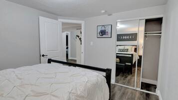 A bedroom with a bed, a closet, and a bathroom visible through an open door.
