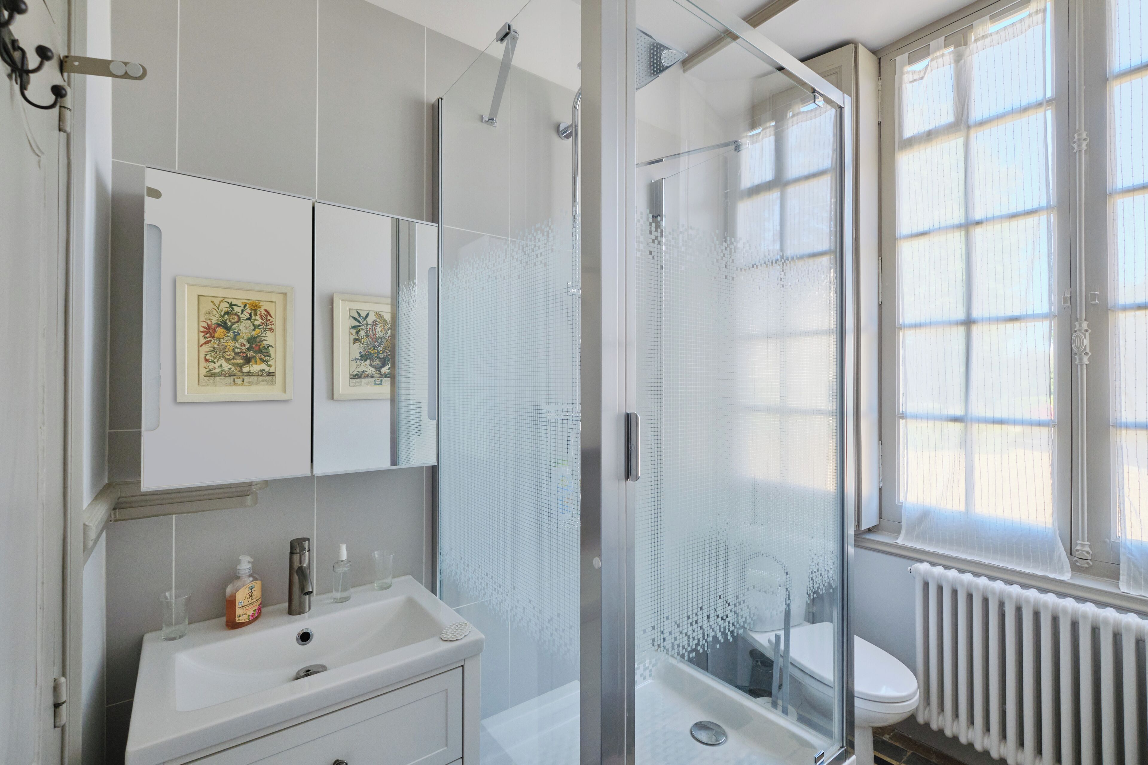 Une salle de bain moderne avec une douche à parois de verre, un lavabo blanc et des toilettes.