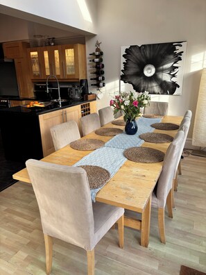 Ein Essbereich mit einem Holztisch, beigen Stühlen und einer Blumenvase.