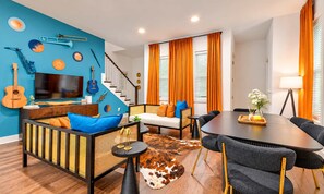 Un salon moderne avec un canapé, une table à manger et un escalier.