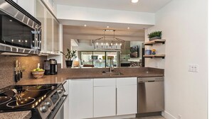 A modern kitchen with a built-in stove, microwave, and dishwasher. - STUNNING FURNISHED POOLSIDE HOME AT MISSION HILLS COUNTRY CLUB RANCHO MIRAGE (Rancho Mirage)