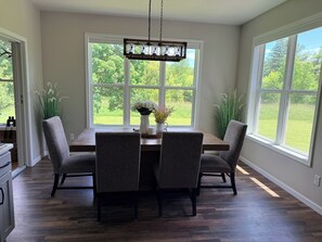 Comedor con mesa de madera, dos sillas y una lámpara colgante.
