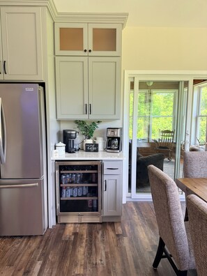 A kitchen with a refrigerator, cabinets, a coffee maker, and a coffee station. - A Private Retreat Near Road America, Walk to Downtown Elkhart Lake, Sleeps 12 (Elkhart Lake)