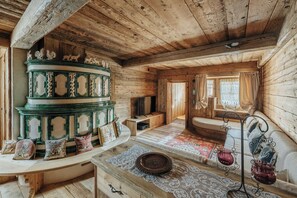 A rustic wooden interior with a multi-tiered green and white cabinet, a woven rug, and a metal stand holding red glass jars. - Charming Luxury Chalet in Cortina d'Ampezzo (Cortina d'Ampezzo)