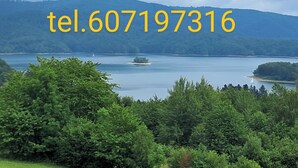 Ein See, umgeben von Bäumen und Hügeln.
