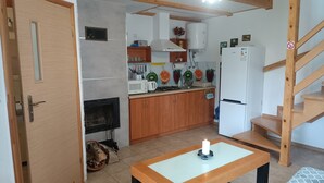 Eine kleine Küche mit Holzausstattung, einer Mikrowelle und einem Kühlschrank.