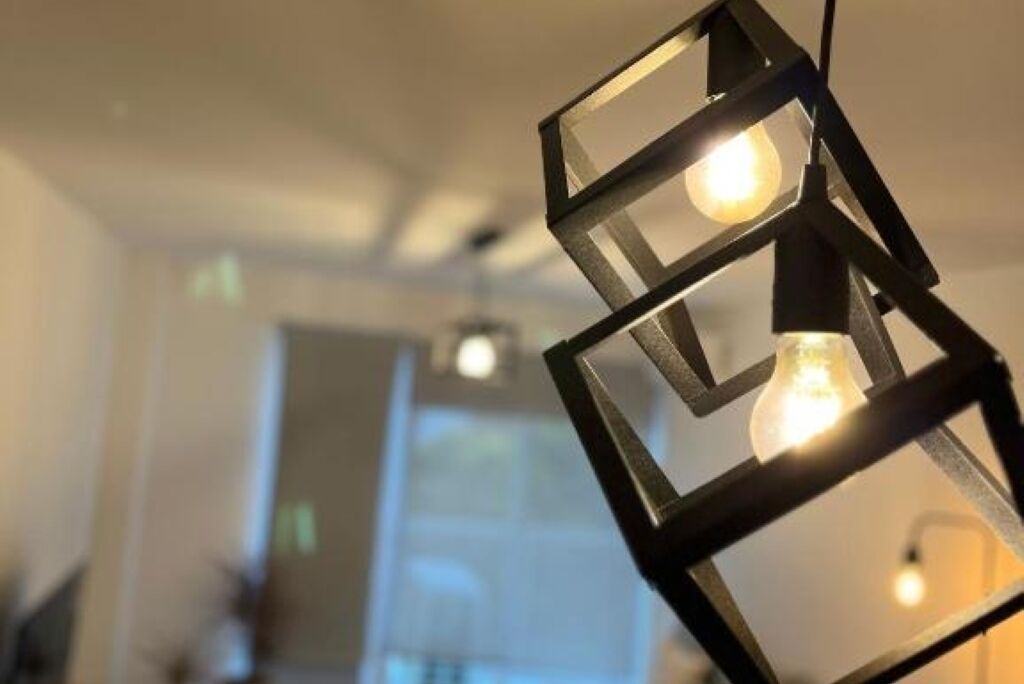 A modern interior with geometric light fixtures and a visible door in the background.
