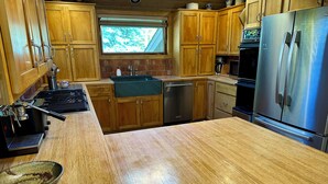 A kitchen with wooden cabinets, a stainless steel refrigerator, a sink, and a coffee machine. - Private 4 Bedroom 4 Bath Sun Valley Getaway. Hot Tub/Large Yard/ Dog Friendly (Sun Valley)