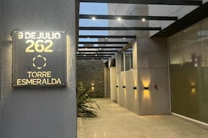 Ingresso di un edificio moderno con una targa che riporta la scritta "9 de Julio 262 Torre Esmeralda".