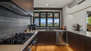 Een moderne keuken met een fornuis, spoelbak en vaatwasser.