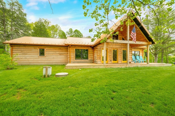 Spacious log cabin retreat with expansive green lawn and forest views
