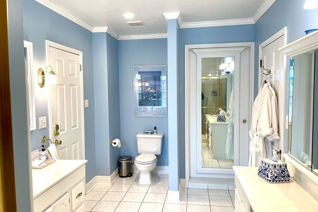 A bathroom with a toilet, sink, and mirror.