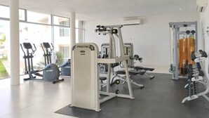 Ein modernes Fitnessstudio mit Cardiogeräten, Krafttrainingsgeräten und viel Tageslicht.