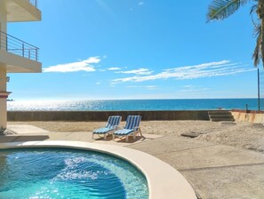 Una piscina amb gandules i vista a l'oceà.