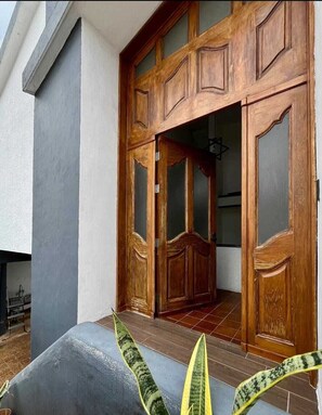 A wooden double door with glass panels, leading into a building. - Casa Chelly - Located a few blocks from the heart of Merida's historic center. (Mérida)