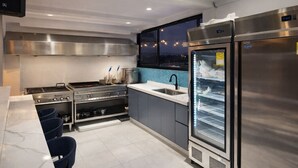 Eine moderne Küche mit Edelstahlgeräten, einem großen Kühlschrank und einem Fenster mit Blick auf die Stadt.