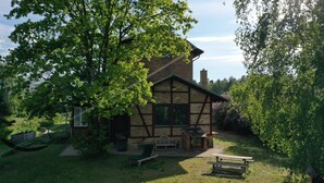 A traditional stone building with a large tree in the yard, a hammock, and a picnic table. - Vacation apartment in the old country station 2nd floor (Schwarz)