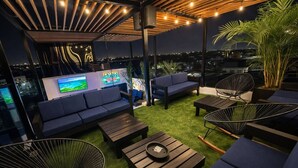 A rooftop lounge with a TV, sofas, and a grill. - Isla Mar Room – Peaceful Caribbean-Inspired Stay (Cartagena de Indias)
