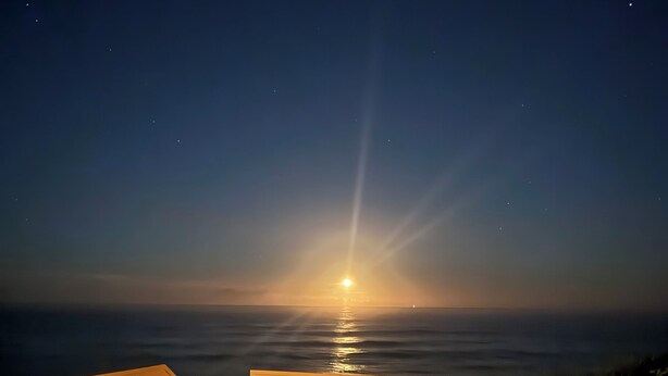 A wooden deck with a railing, overlooking a sunset over the ocean. - Stunning Ocean Views! 2-bedroom house, private beach in Melbourne Beach, FL (Melbourne Beach)
