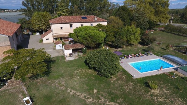 Una propiedad residencial con piscina, garaje independiente y un amplio césped.