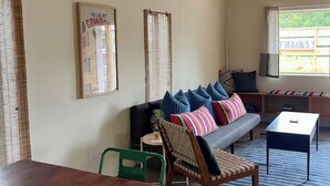A cozy living room with a sofa, chairs, and a TV. - La Palomita - Modern Casita in the Heart of Marfa TX (Marfa)