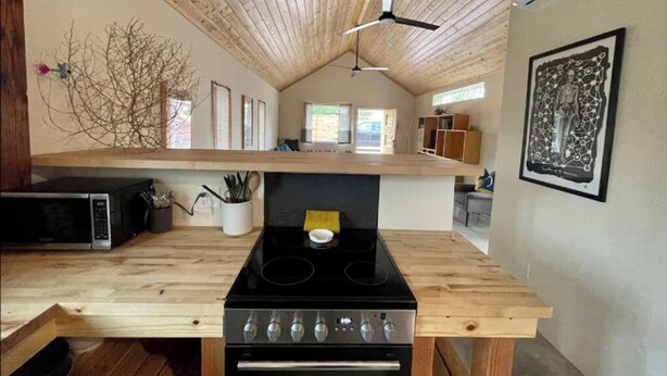 A kitchen with a wooden countertop, a black stove, and a microwave. - La Palomita - Modern Casita in the Heart of Marfa TX (Marfa)