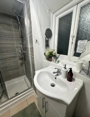 Een douche, handdoeken, zeep, toiletpapier